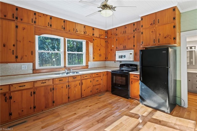 kitchen with light wood-type flooring, ornamental molding, ceiling fan, sink, and black appliances