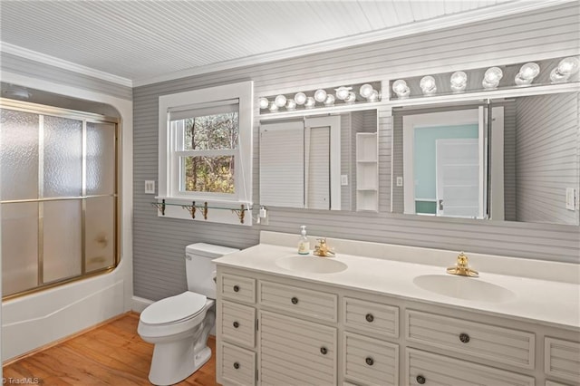 full bathroom with ornamental molding, vanity, wood-type flooring, enclosed tub / shower combo, and toilet