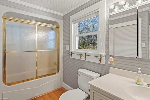 full bathroom featuring vanity, wooden walls, enclosed tub / shower combo, hardwood / wood-style floors, and toilet