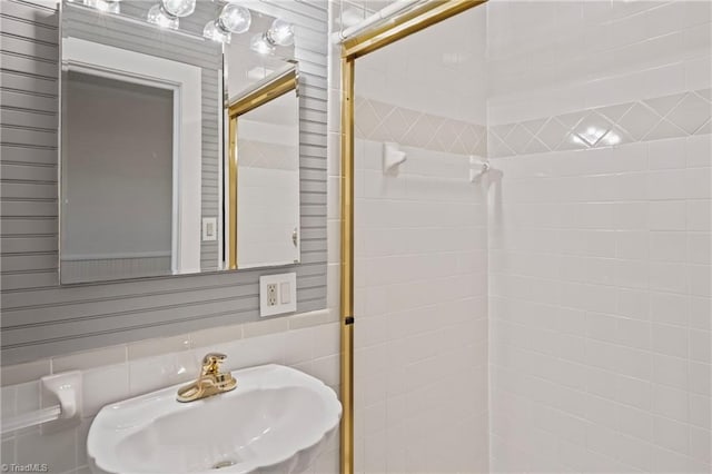 bathroom featuring sink and tile walls