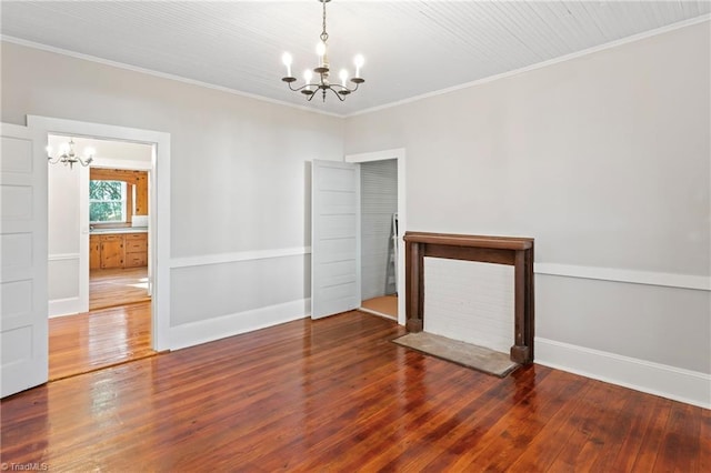 empty room featuring crown molding, wood-type flooring, and an inviting chandelier