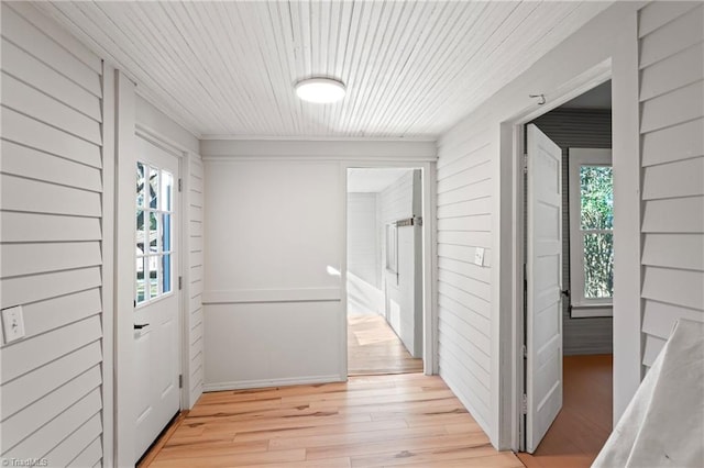 interior space with wooden walls, wooden ceiling, light hardwood / wood-style flooring, and a healthy amount of sunlight