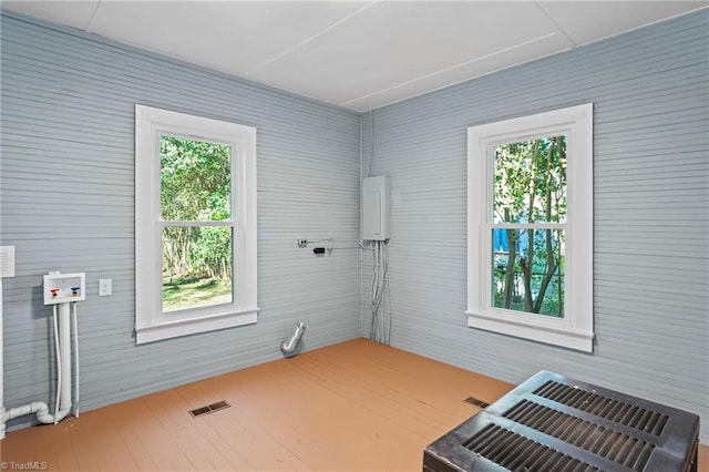 clothes washing area featuring hardwood / wood-style flooring, hookup for an electric dryer, a wealth of natural light, and washer hookup