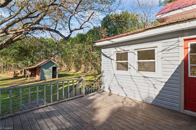 wooden deck with a lawn and a storage shed