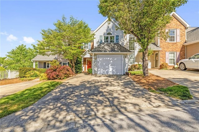 view of front of home with concrete driveway, brick siding, an attached garage, and fence