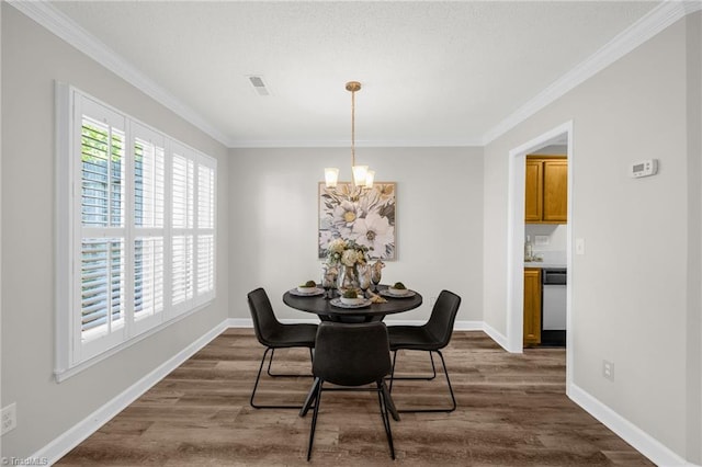 dining space featuring ornamental molding, dark wood finished floors, and a chandelier