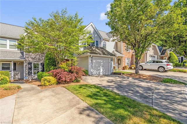 view of front of property featuring a garage, a residential view, and concrete driveway