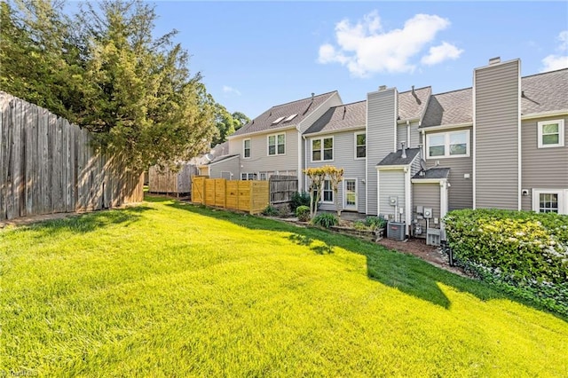rear view of house featuring fence and a lawn
