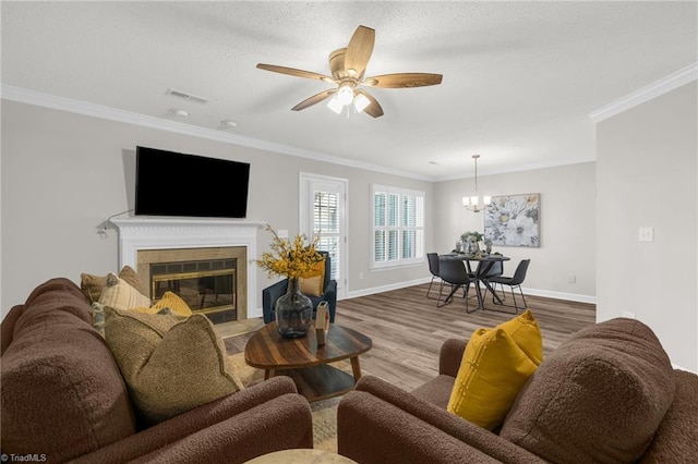 living area with ornamental molding, wood finished floors, and visible vents