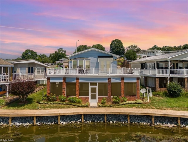 back house at dusk with a water view