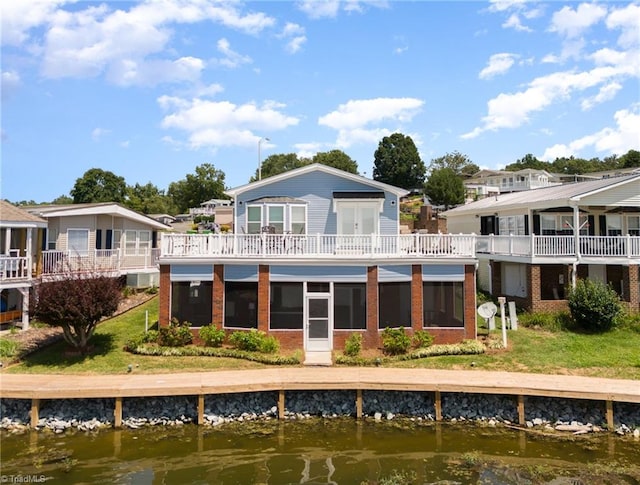 rear view of house with a lawn and a water view