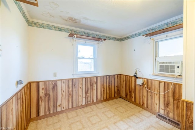 empty room with ornamental molding, cooling unit, baseboard heating, and wooden walls