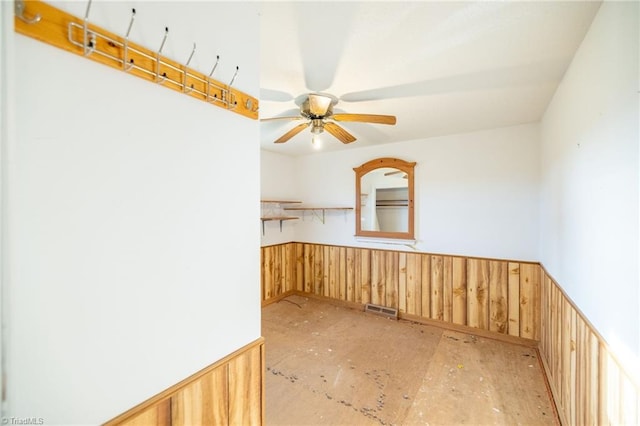 empty room with wooden walls and ceiling fan