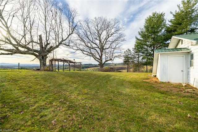 view of yard with a rural view and a shed