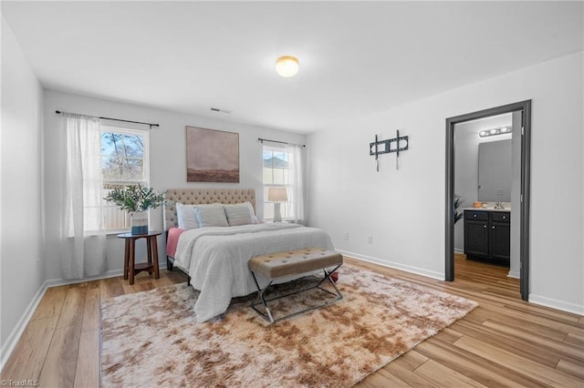 bedroom featuring light wood-type flooring and ensuite bathroom