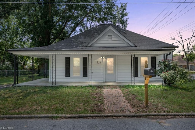 view of front of house with a lawn, a carport, and covered porch