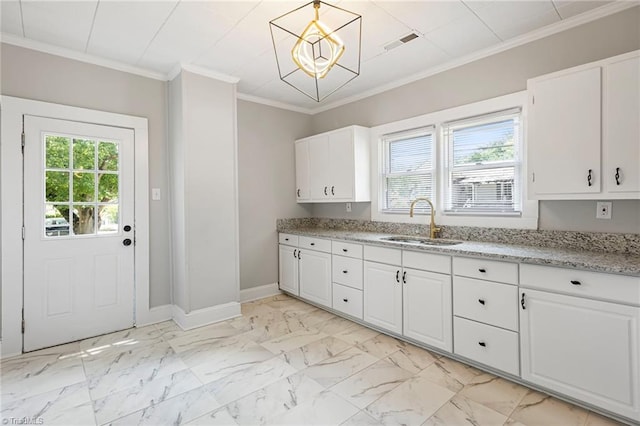 kitchen with decorative light fixtures, sink, white cabinets, ornamental molding, and light stone counters