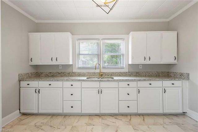 kitchen with ornamental molding, sink, and white cabinets