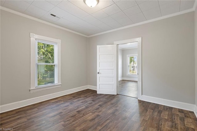 unfurnished room with ornamental molding, a healthy amount of sunlight, and dark hardwood / wood-style floors