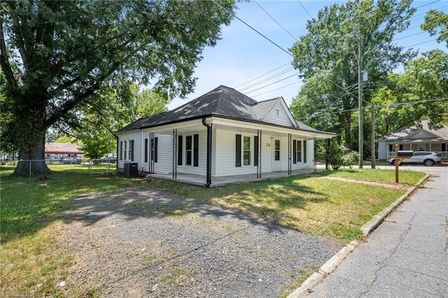 view of front facade with central AC unit, covered porch, and a front lawn