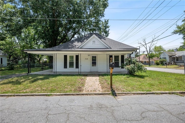 view of front of property with a front lawn, a carport, and covered porch