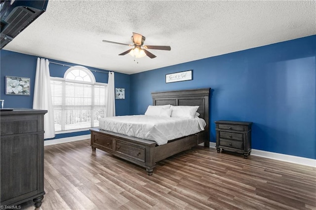 bedroom with a textured ceiling, hardwood / wood-style flooring, and ceiling fan