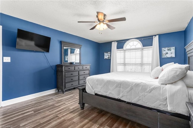 bedroom with hardwood / wood-style flooring, ceiling fan, and a textured ceiling