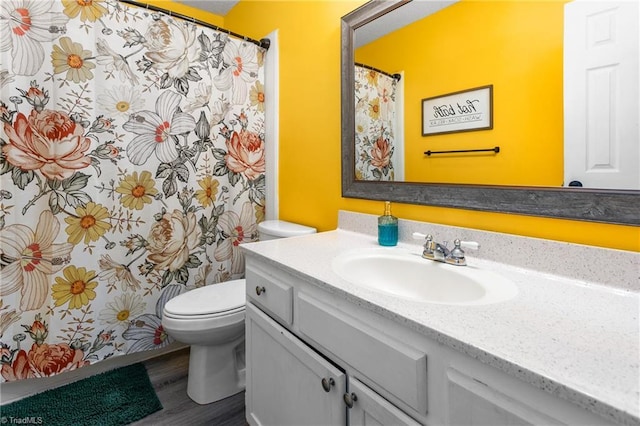 bathroom with toilet, wood-type flooring, and vanity