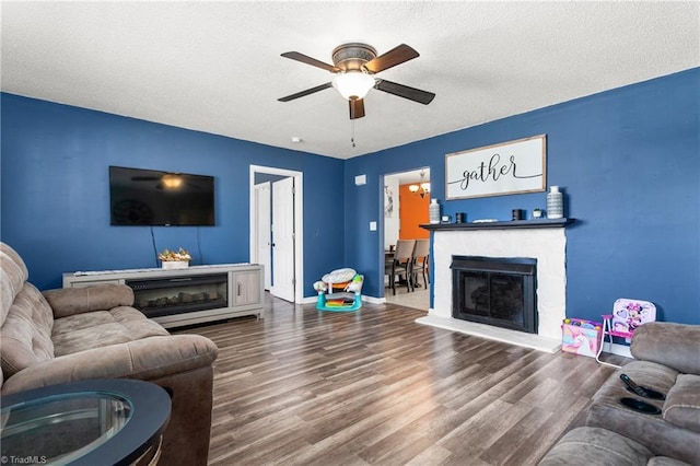 living room with ceiling fan, wood-type flooring, and a textured ceiling