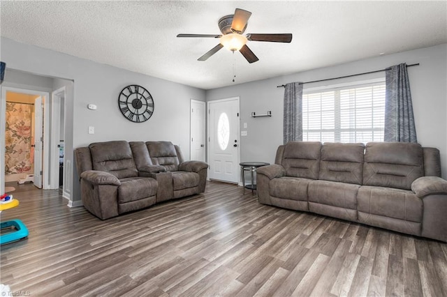 living room featuring hardwood / wood-style floors, ceiling fan, and a textured ceiling