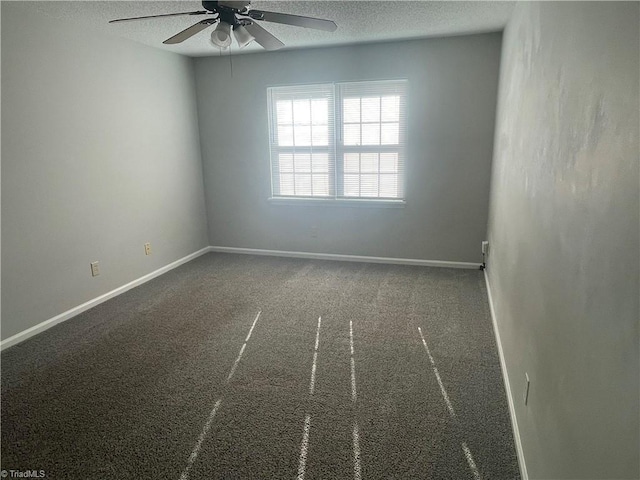 carpeted spare room featuring baseboards, a ceiling fan, and a textured ceiling