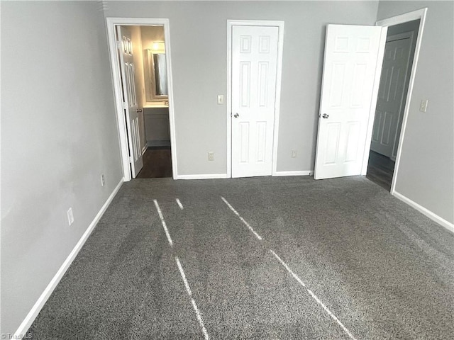 unfurnished bedroom featuring baseboards, carpet flooring, and connected bathroom