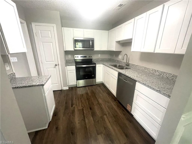 kitchen featuring a sink, white cabinetry, dark wood-style floors, and stainless steel appliances