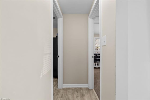 corridor with light hardwood / wood-style floors