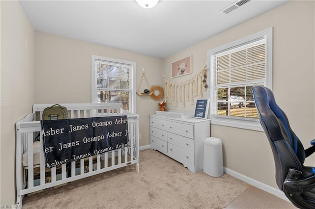 bedroom with light carpet and a nursery area