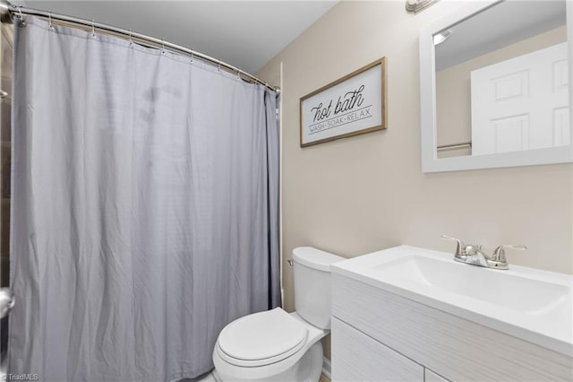 bathroom with a shower with shower curtain, vanity, and toilet