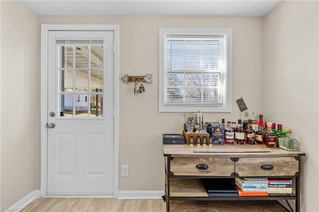 entrance foyer featuring bar area and light hardwood / wood-style flooring