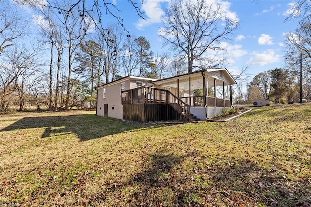 rear view of property with a lawn, a sunroom, and a deck