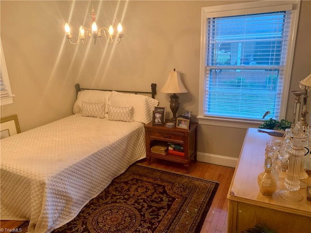 bedroom with an inviting chandelier and wood-type flooring