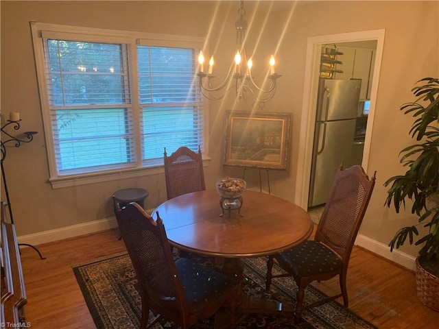 dining area featuring hardwood / wood-style flooring and an inviting chandelier