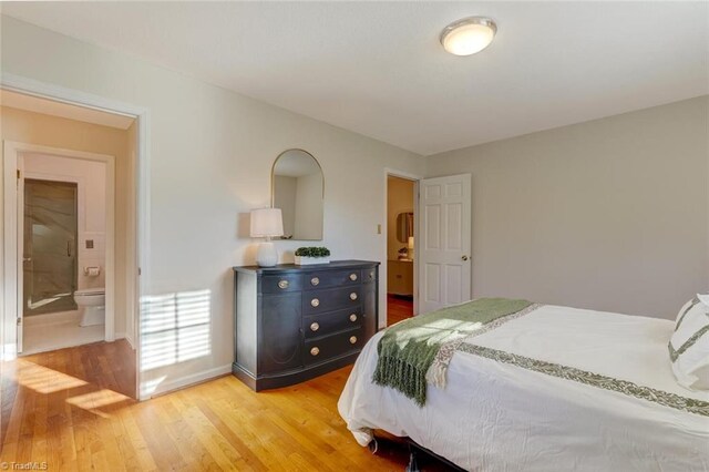 bedroom featuring ensuite bathroom and hardwood / wood-style floors