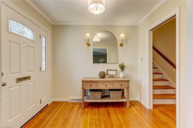 entrance foyer featuring hardwood / wood-style floors and crown molding