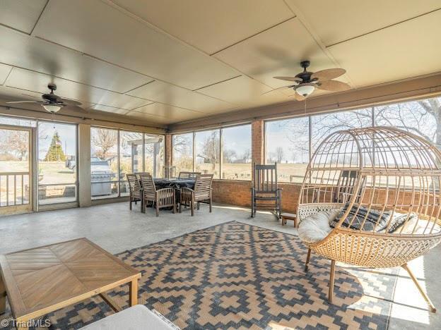 sunroom with a ceiling fan and a wealth of natural light