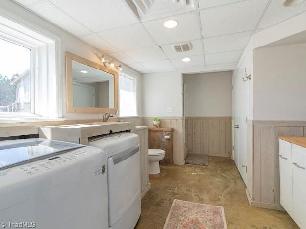 bathroom featuring a paneled ceiling, a wainscoted wall, visible vents, and separate washer and dryer