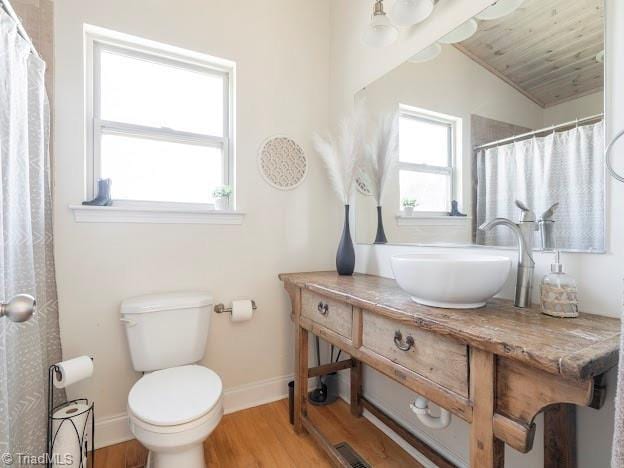 bathroom featuring toilet, baseboards, a sink, and wood finished floors