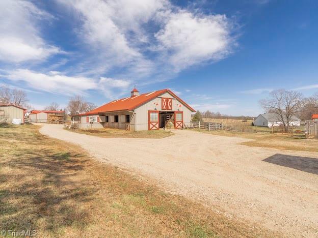 exterior space featuring an outbuilding, driveway, and fence