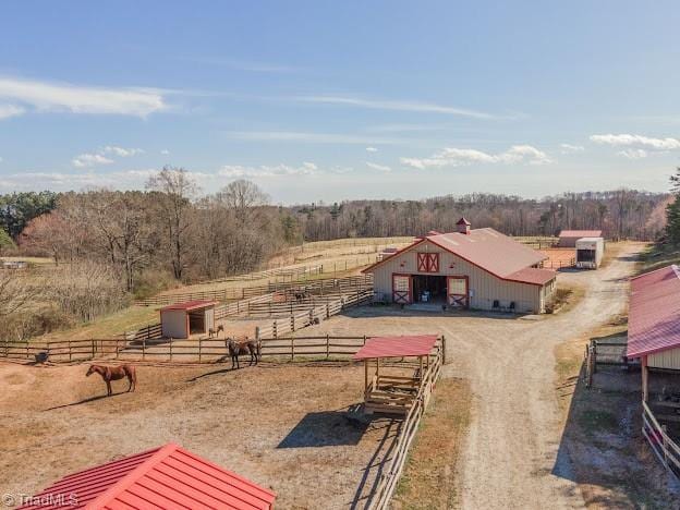 view of yard featuring a rural view, an outdoor structure, an exterior structure, and fence