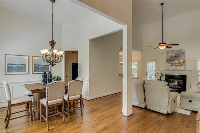 3001 Walbrook Ter, Browns Summit, NC 27214 - dining area with high vaulted ceiling, a chandelier, a glass covered fireplace, and light wood finished floors