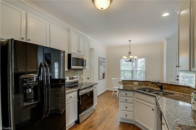 3001 Walbrook Ter, Browns Summit, NC 27214 - kitchen featuring appliances with stainless steel finishes, a sink, plenty of natural light, a chandelier, and recessed lighting