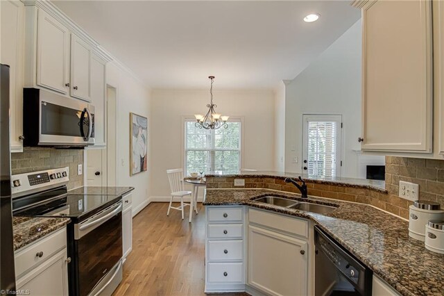 3001 Walbrook Ter, Browns Summit, NC 27214 - kitchen featuring appliances with stainless steel finishes, a sink, a peninsula, a chandelier, and decorative backsplash